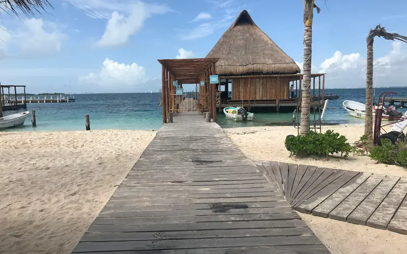 Wooden pier leading to a palapa over the water