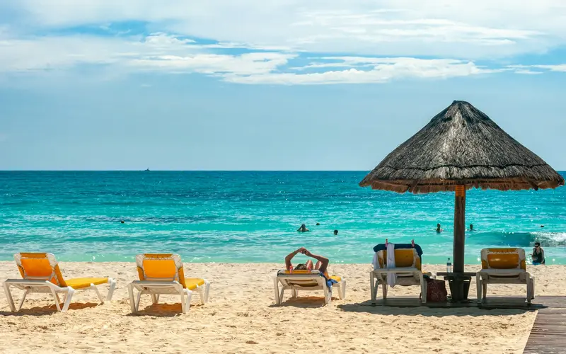 Loungers under a palapa on the beach