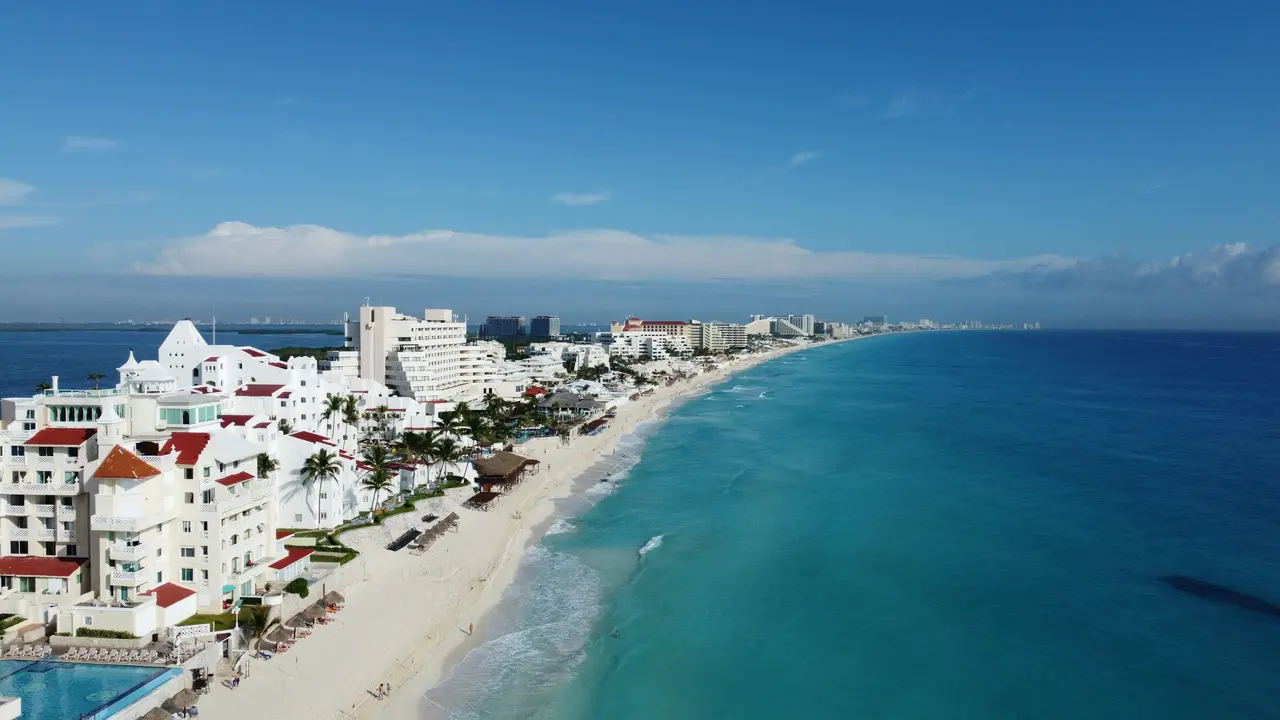 Cancún coastline with white buildings and blue sea from above