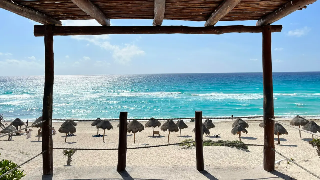 Wooden pergola overlooking the beach and palapas