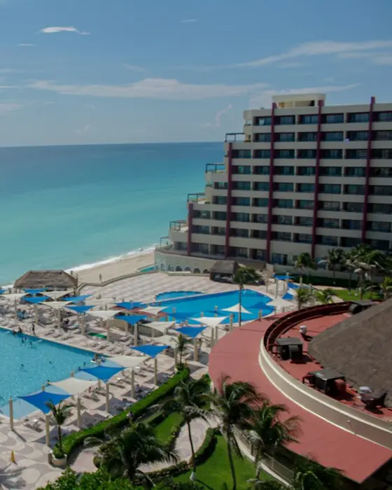 Oceanfront building with a pool and palms