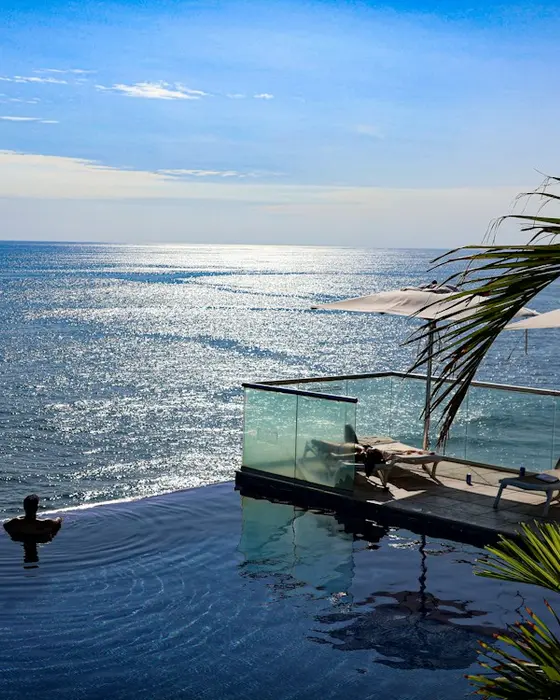 Infinity-edge rooftop pool facing the Caribbean sea